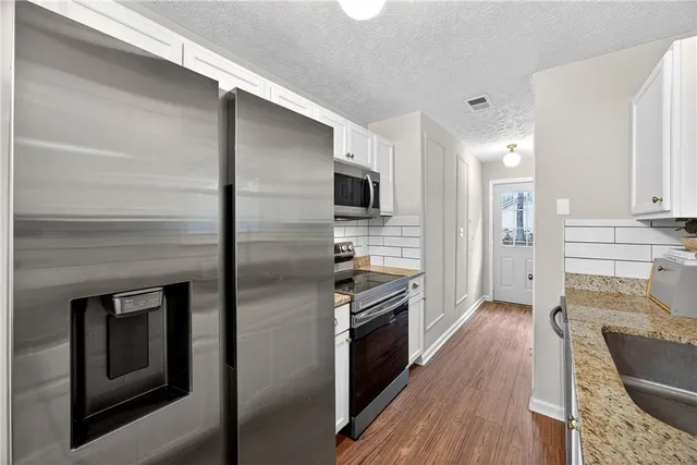 a kitchen with a refrigerator stove and oven