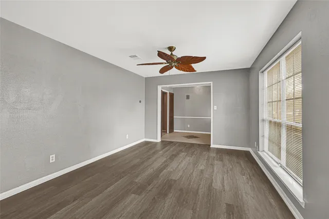 a view of room with window ceiling fan and hardwood floor