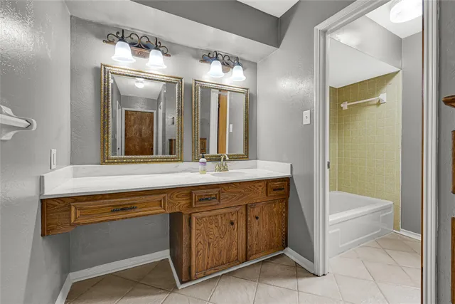 a bathroom with a sink a large mirror and a bathtub