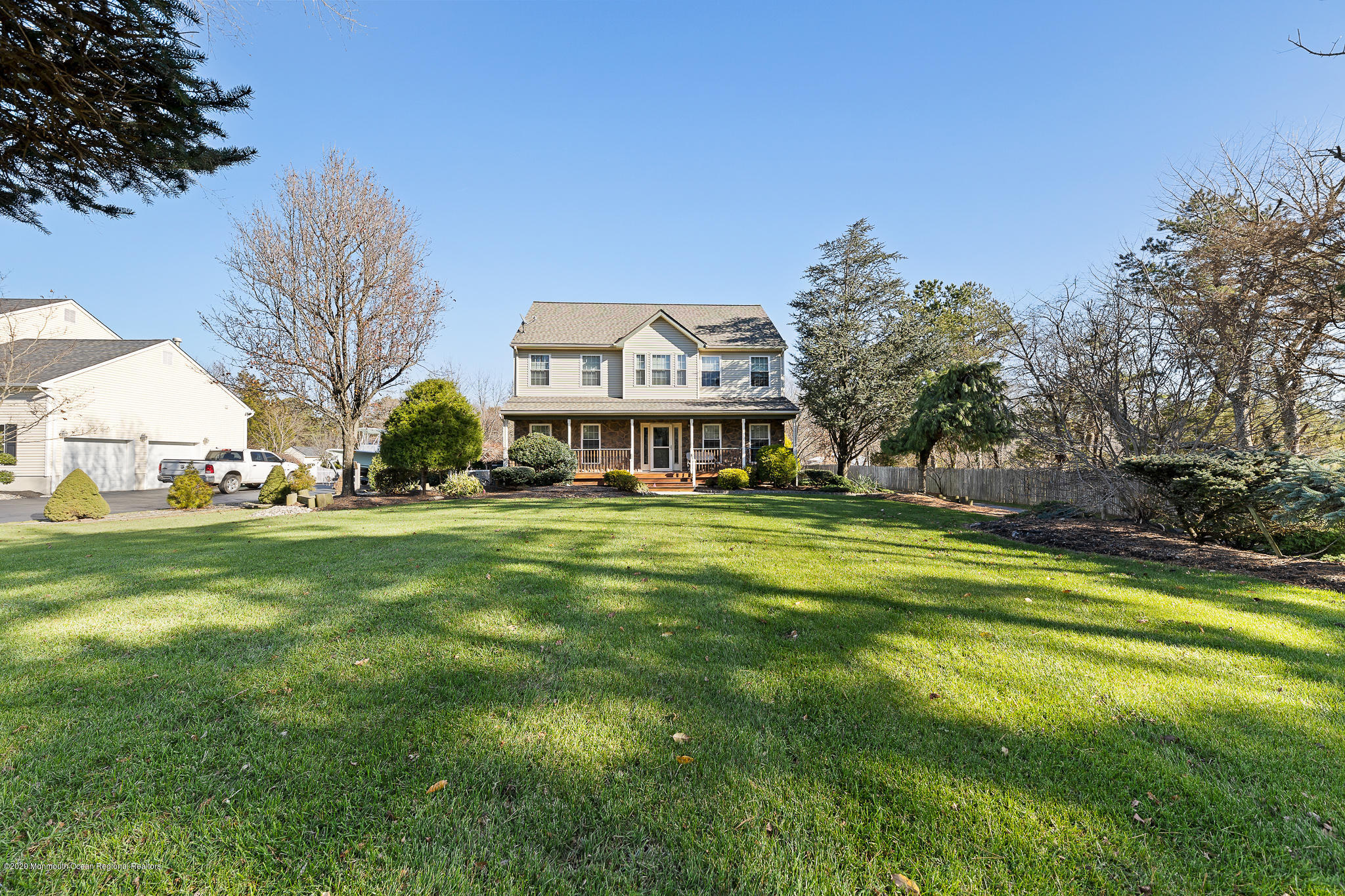 a front view of house with yard and trees in the background