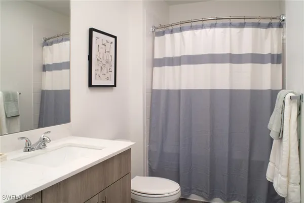 a bathroom with a sink a toilet and shower curtain