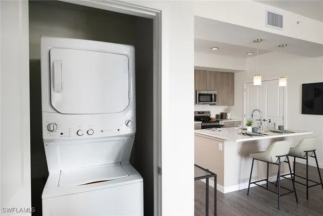 a view of kitchen with kitchen island a sink a stove and wooden floor