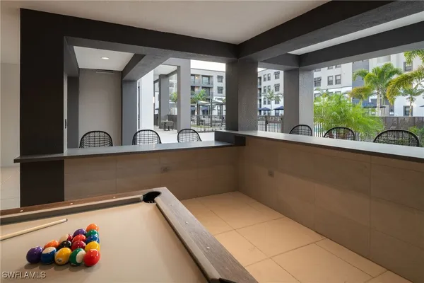 a room with pool table and windows