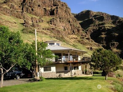 a front view of a house with a garden and swimming pool