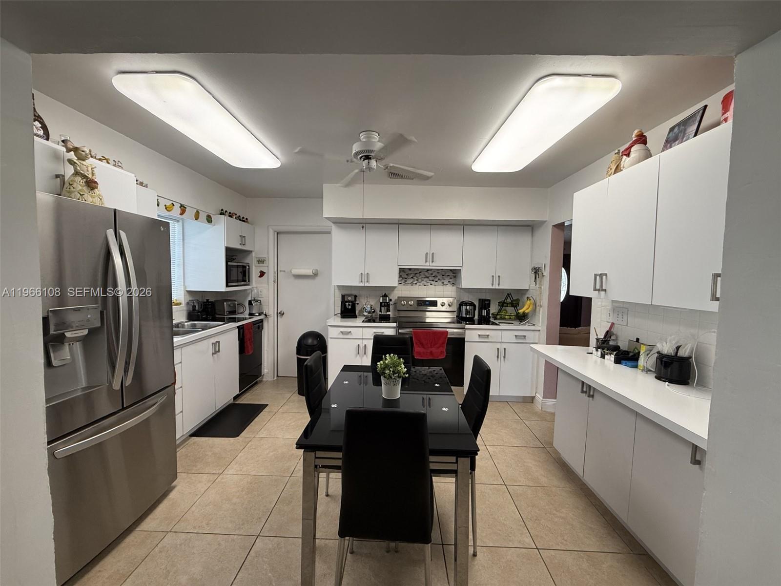 4012 Southwest 102nd Court Miami, FL 33165 - Photo 4 of 10 a kitchen with stainless steel appliances a refrigerator sink and cabinets