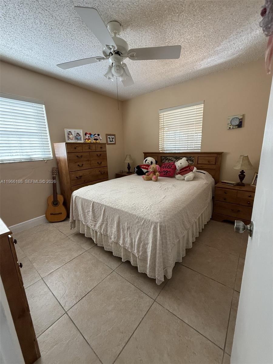 4012 Southwest 102nd Court Miami, FL 33165 - Photo 5 of 10 a bedroom with a bed and a table