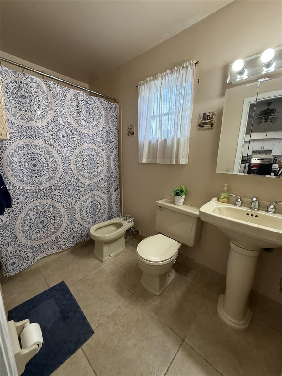 4012 Southwest 102nd Court Miami, FL 33165 - Photo 6 of 10 a bathroom with a toilet sink and mirror