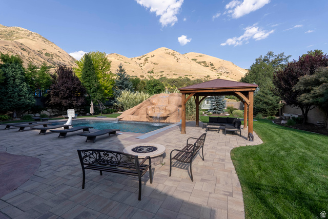 687 South 2080th Street East Springville, UT 84663 - Photo 93 of 149 Expansive paver patio featuring a swimming pool with rock waterfall feature, a fire pit, and a wooden gazebo