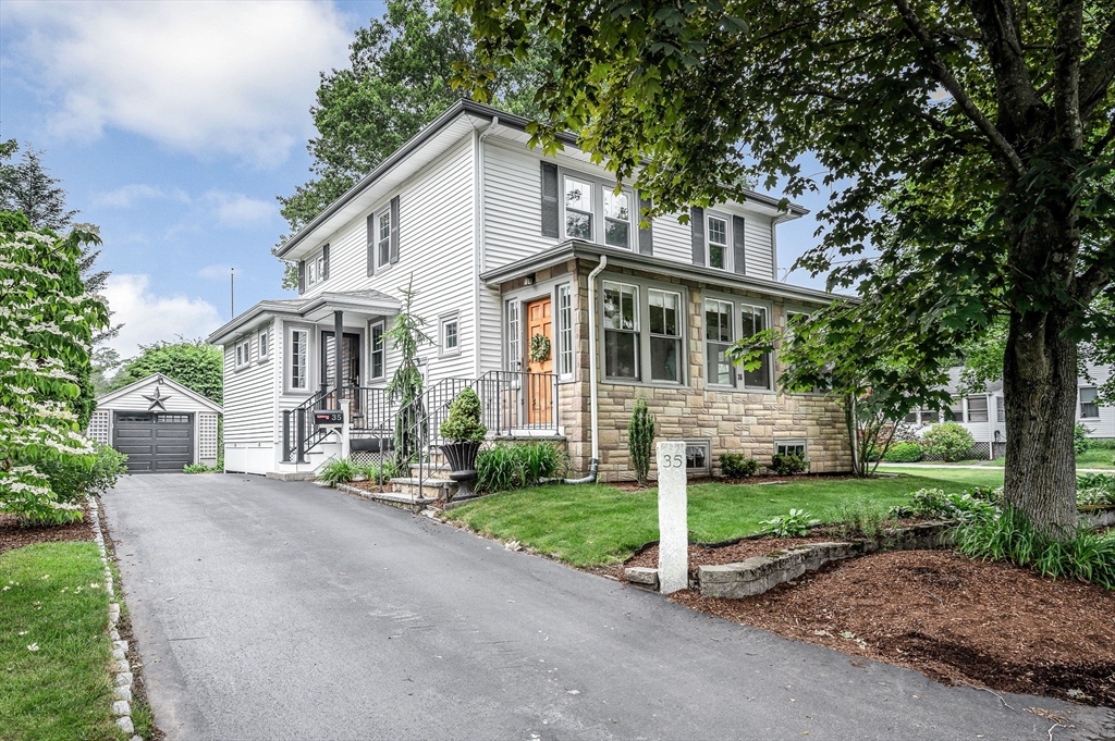 a front view of a house with a yard and trees