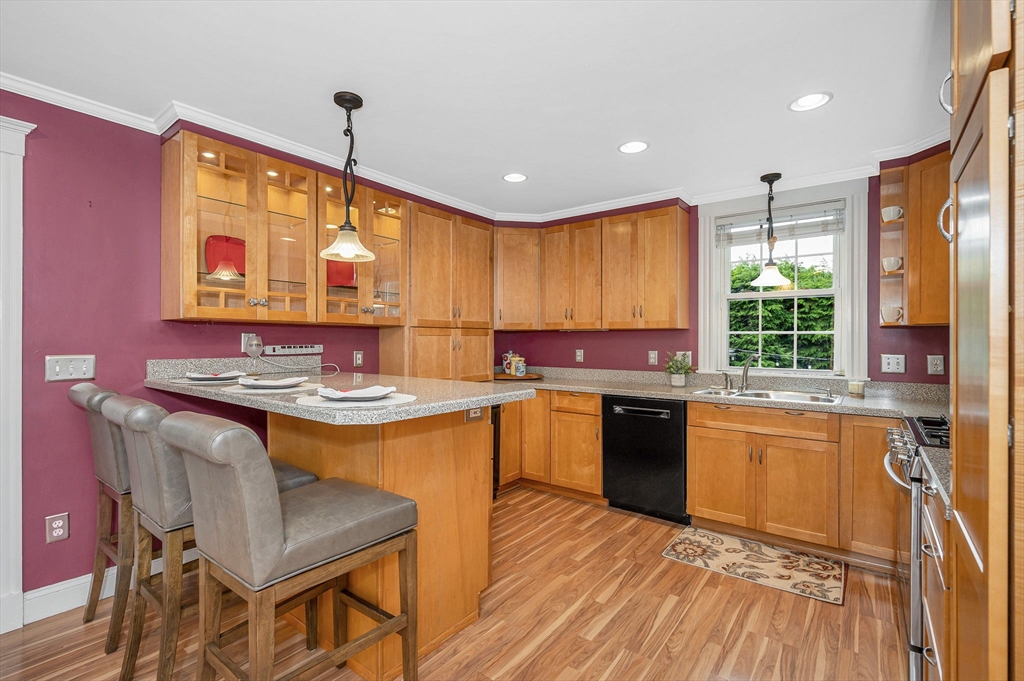 35 Warren Avenue Reading, MA 01867 - Photo 14 of 41 a kitchen with kitchen island granite countertop wooden cabinets and a stove