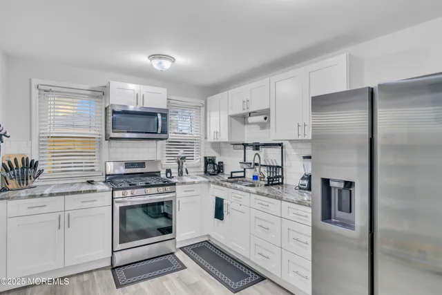 a kitchen with cabinets stainless steel appliances and a sink