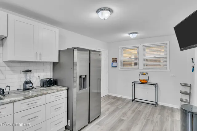 a kitchen with stainless steel appliances a refrigerator sink and wooden floor
