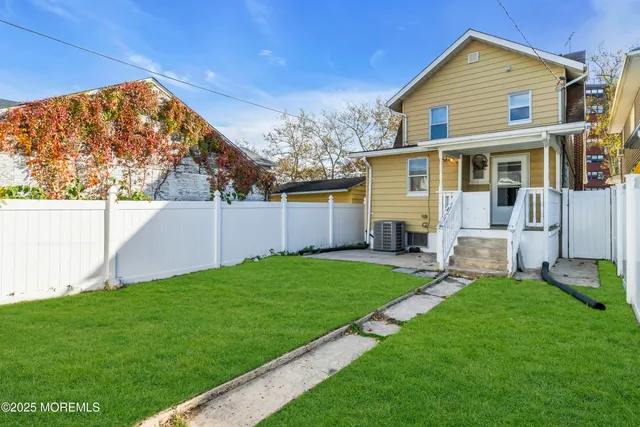 a view of a backyard with plants and a fence