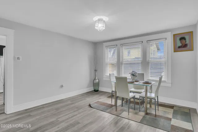 a dining room with wooden floor and a floor to ceiling window