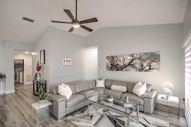 a living room with furniture and a wooden floor