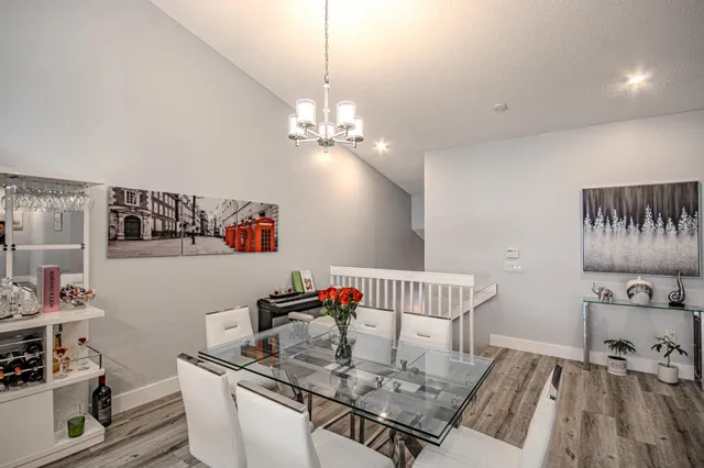 a kitchen with stainless steel appliances a refrigerator a sink a stove a table and chairs