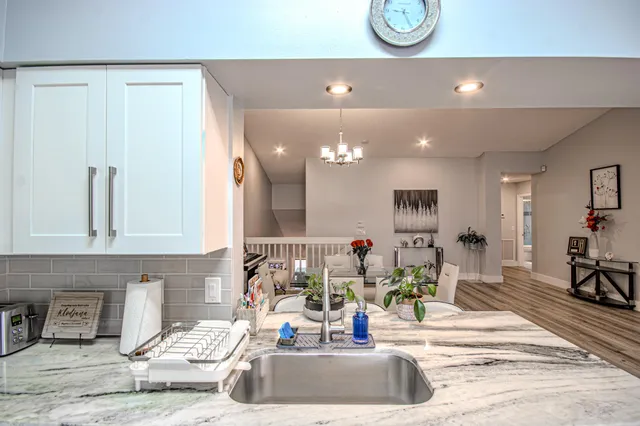 a bedroom with a bed a chandelier and a dresser