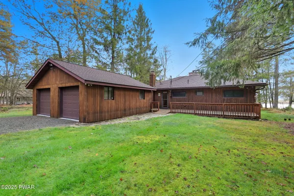 a view of backyard of house with wooden fence