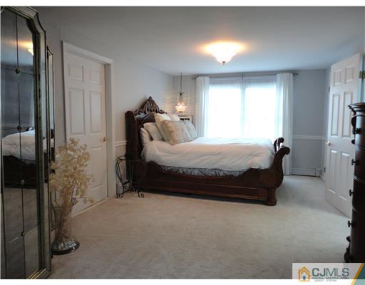21 Longfield Road New Brunswick, NJ 08901 - Photo 8 of 19 a bed sitting in a bedroom next to a window and a chandelier