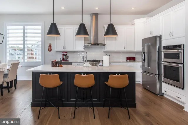 a view of a hallway with wooden floor and a bathroom