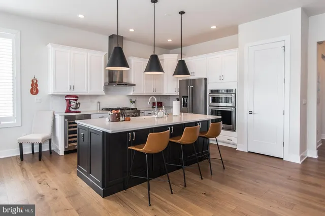 a view of a hallway with wooden floor and a bathroom