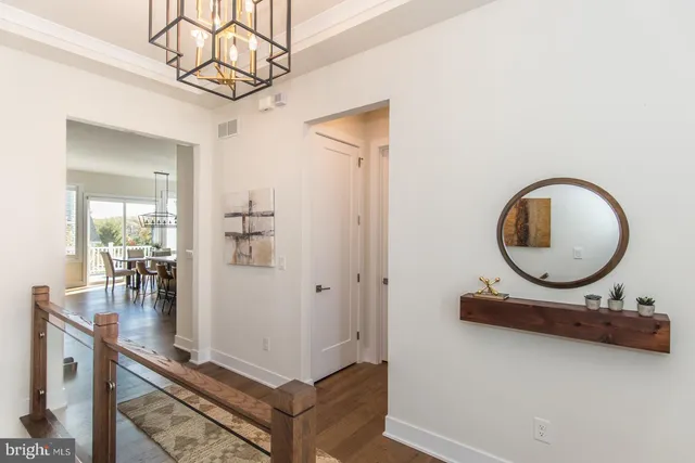 a living room with furniture kitchen view and a wooden floor
