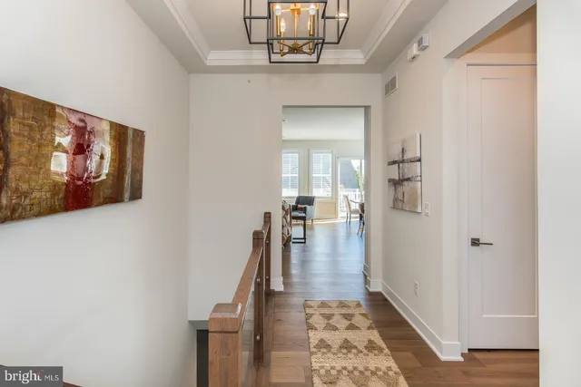 a kitchen with stainless steel appliances kitchen island granite countertop a stove a sink a refrigerator and white cabinets with wooden floor