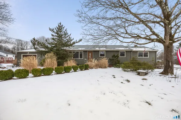 a front view of a house with a yard covered in snow