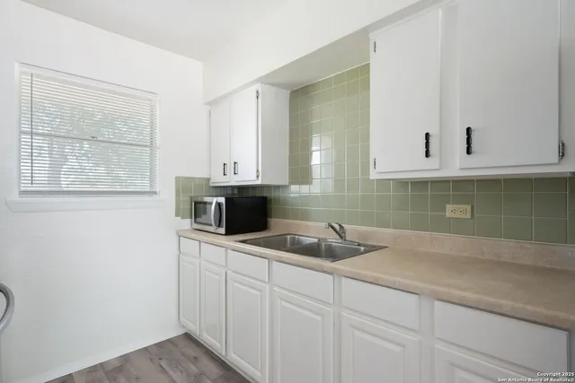 a kitchen with white cabinets and a sink