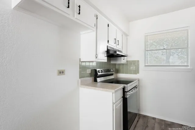 a kitchen with stainless steel appliances a sink stove and a window