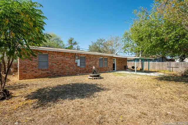 a backyard of a house with barbeque oven and outdoor seating