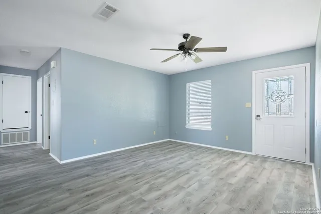a view of room with hardwood floor and ceiling fan
