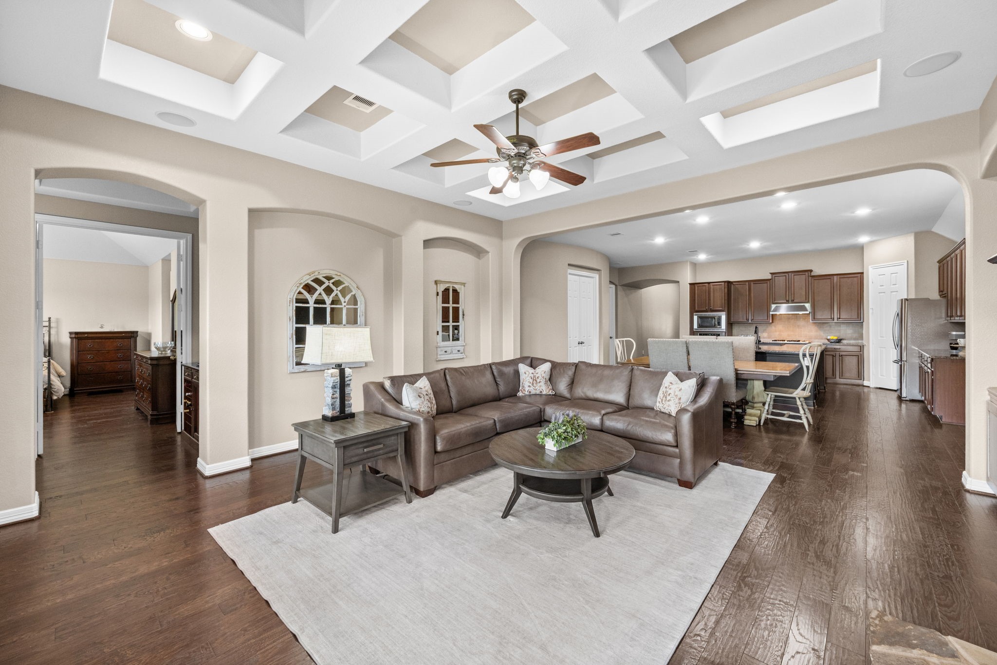 27642 Linden Ridge Lane Fulshear, TX 77441 - Photo 41 of 42 This view looking back toward the Kitchen and Dining Area showcases the impressive depth of the living space and highlights the home's open-concept floor plan. The seamless flow between the Family Room, Dining Area, and Kitchen creates an ideal setting for both everyday living and effortless entertaining.
