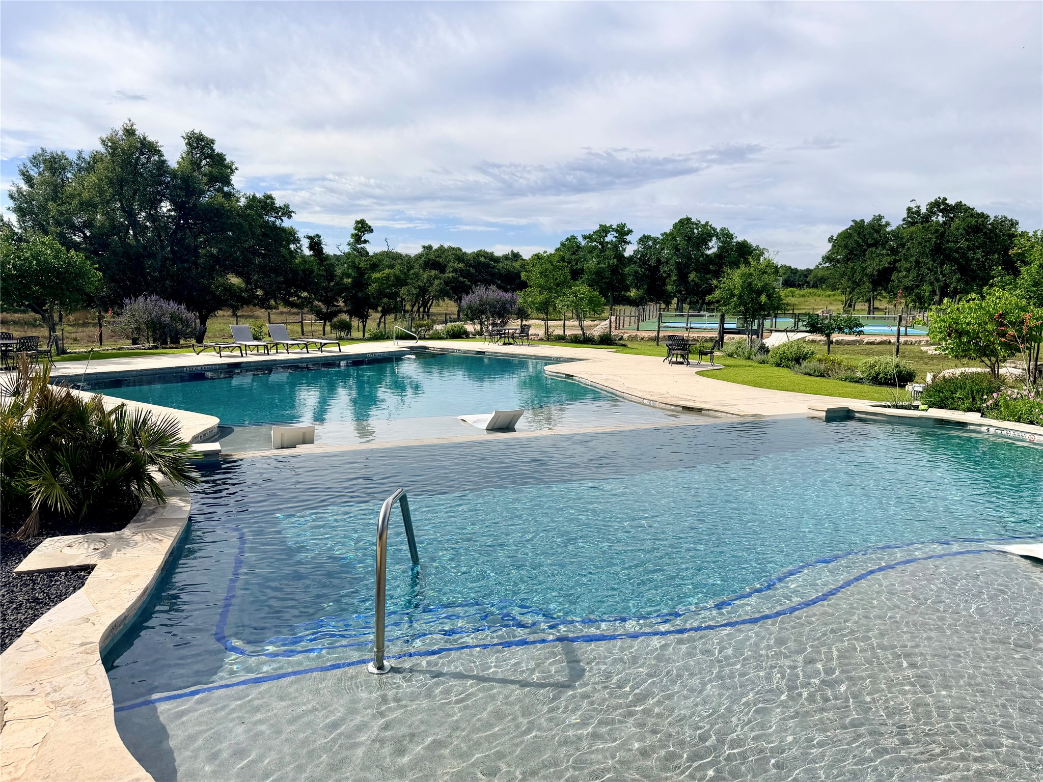 485 Inspiration Loop Comfort, TX 78013 - Photo 19 of 22 An inviting multi-level pool with integrated seating offers refreshing leisure amidst verdant landscaping.