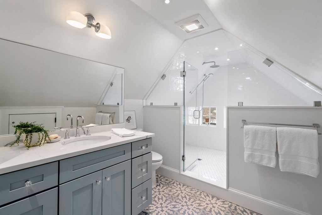 24 Maxfield Street Boston, MA 02132 - Photo 28 of 36 a spacious bathroom with a granite countertop sink a toilet a mirror and shower
