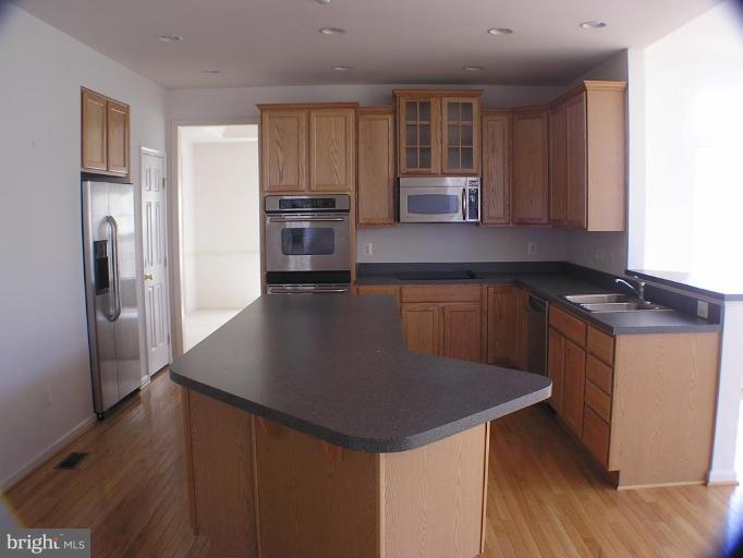 1307 Destrier Street Ranson, WV 25438 - Photo 5 of 15 a kitchen with stainless steel appliances granite countertop a sink a stove a refrigerator and cabinets