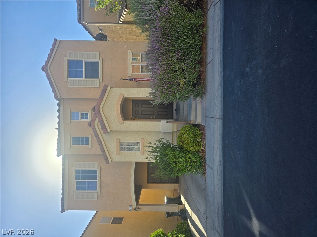 7432 Ademar Street Las Vegas, NV 89148 - Photo 1 of 1 A classic facade with shuttered windows and an inviting entry, framed by established landscaping.