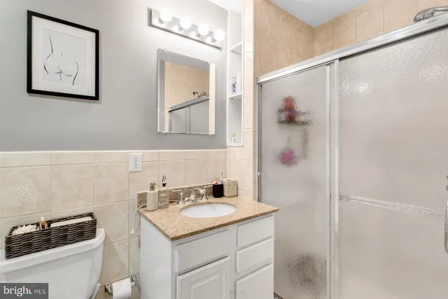 a bathroom with a granite countertop sink mirror and a shower