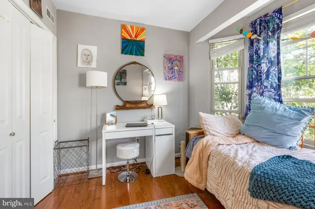 a bedroom with a bed and wooden floor