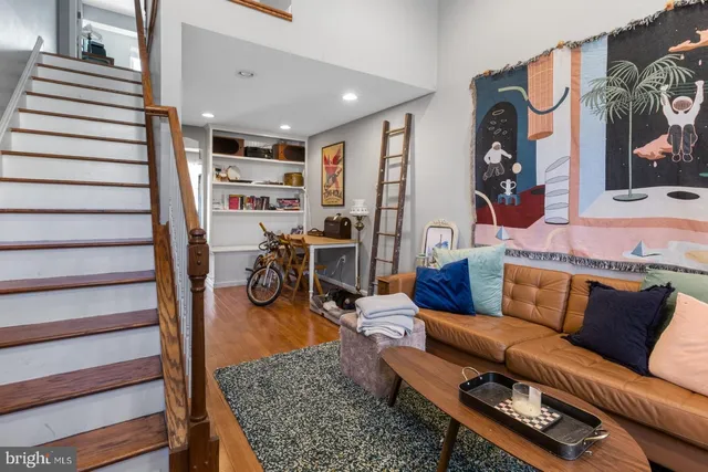 a living room with furniture a rug and white walls