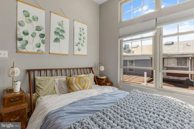 a bedroom with a bed and a large window with outer view