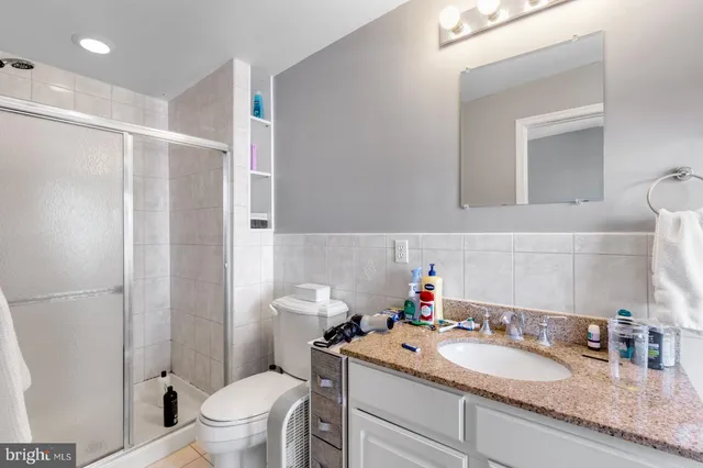 a bathroom with a granite countertop sink mirror vanity and toilet