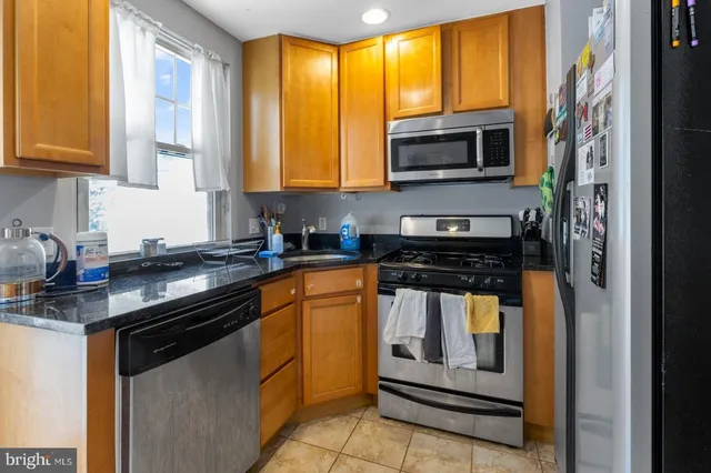 a kitchen with stainless steel appliances granite countertop a stove and a microwave