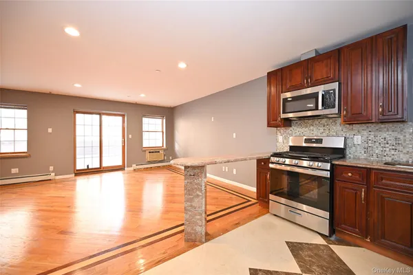 a kitchen with stainless steel appliances granite countertop a stove a sink and a microwave