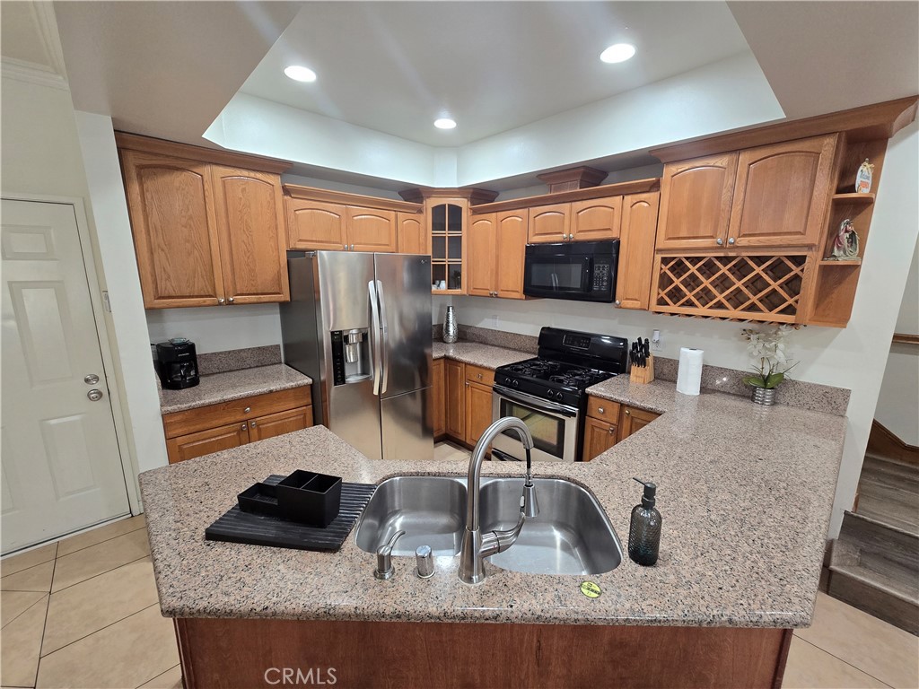 8026 Telegraph Road Downey, CA 90240 - Photo 9 of 26 a kitchen with stainless steel appliances granite countertop a sink and a refrigerator