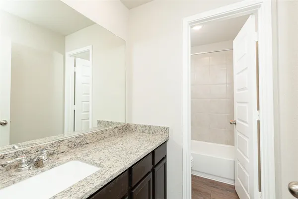 a bathroom with a granite countertop sink and a mirror