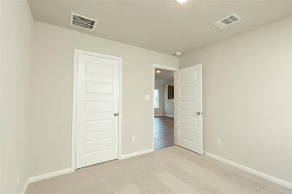 an empty room with closet and entryway