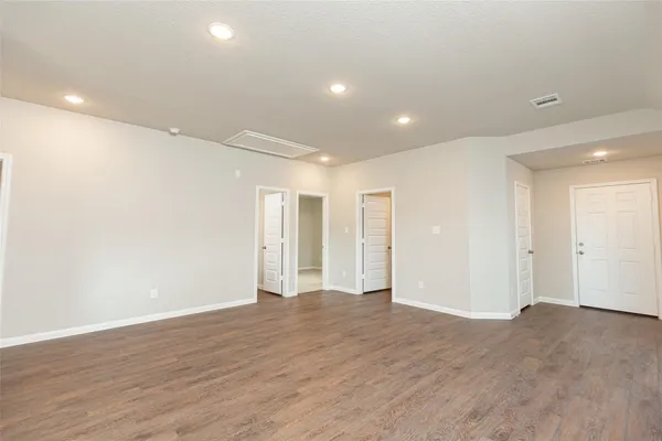 a view of an empty room with wooden floor