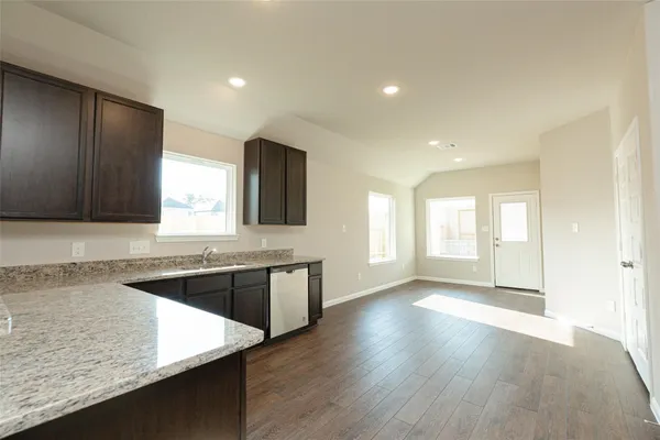 a large kitchen with wooden floor and a sink