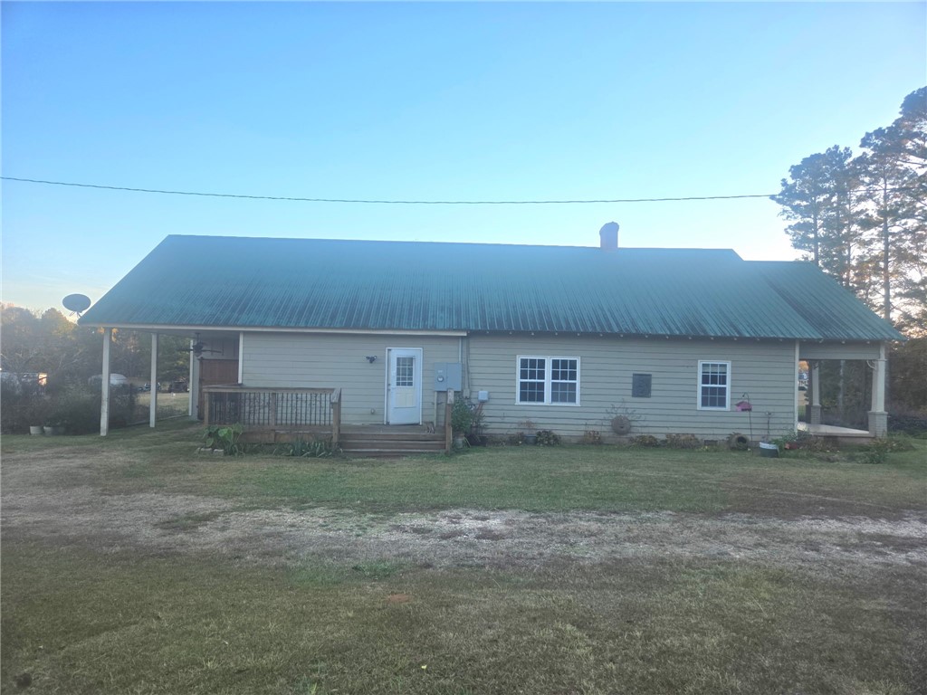 1051 Gage Drive Winder, GA 30680 - Photo 3 of 23 Side view of home with covered carport in back of house. Entrance into kitchen/dining/living area.